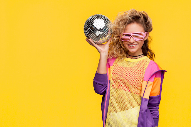 Frau im Retro-Look mit Discokugel und Partybrille
