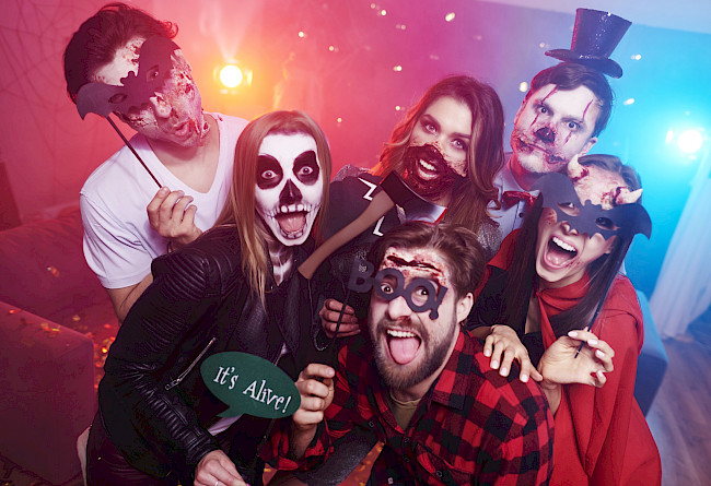 Freunde in Halloween-Kostümen posieren für ein Gruppenfoto