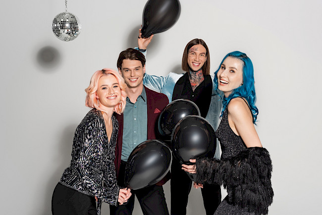 Freunde mit schwarzen Luftballons und Discokugel feiern gemeinsam